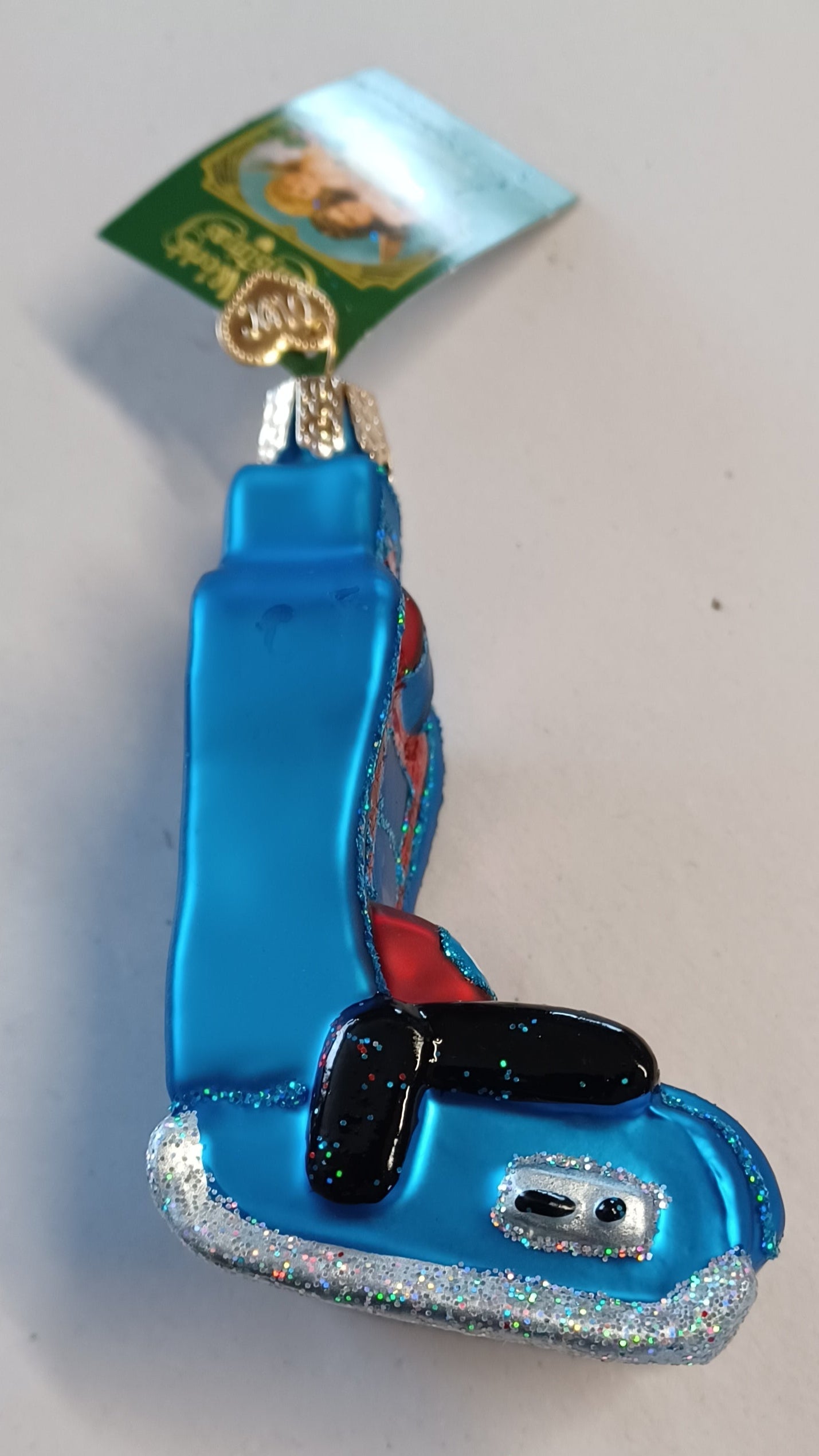 Side view of the blown glass ornament by Old World Christmas. This gaming chair is an adorable gift and sure to please any gamer you gift it to.