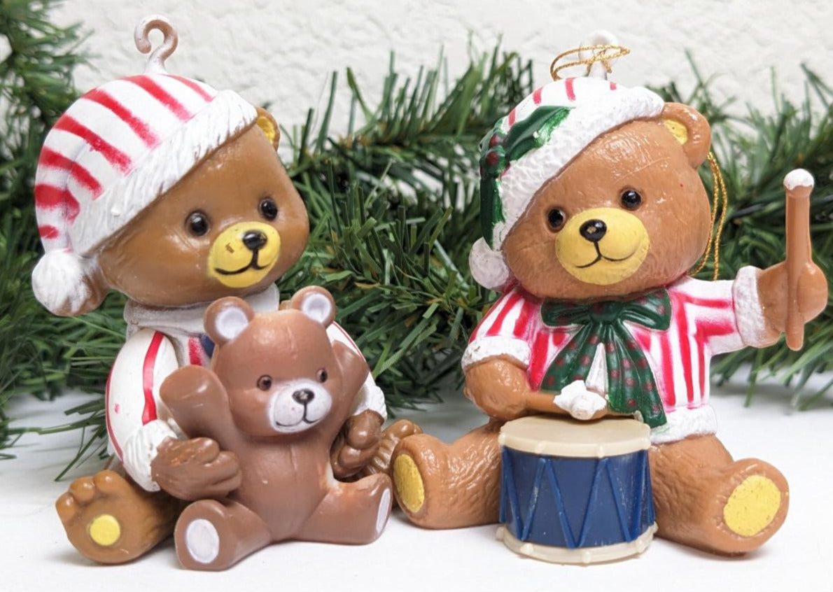 This set of two adorable teddies, each wearing candy striped pajamas and stocking caps are an adorable pair. One teddy plays with their own toy teddy bear while the other bangs away on his new drum set.