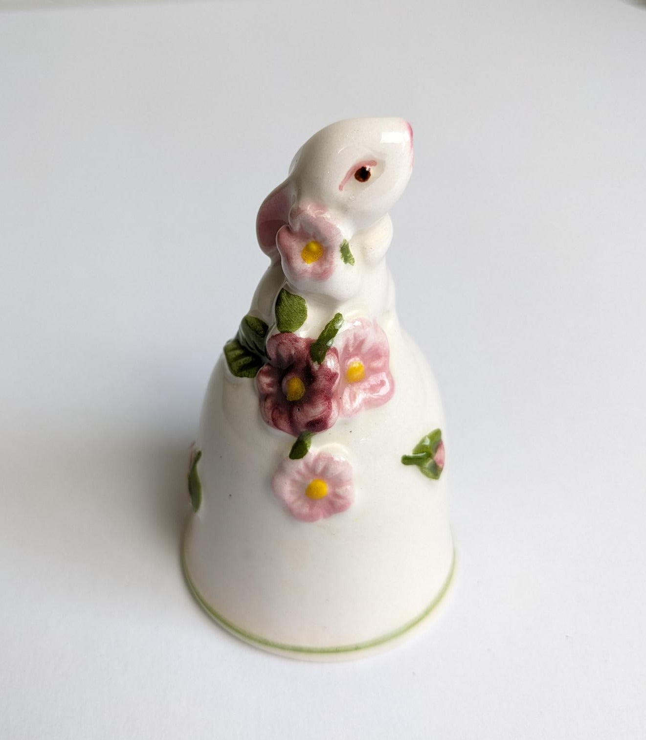 Vintage Avon from 1984. Bell with bunny on top and painted pink and burgundy flowers with yellow centers.