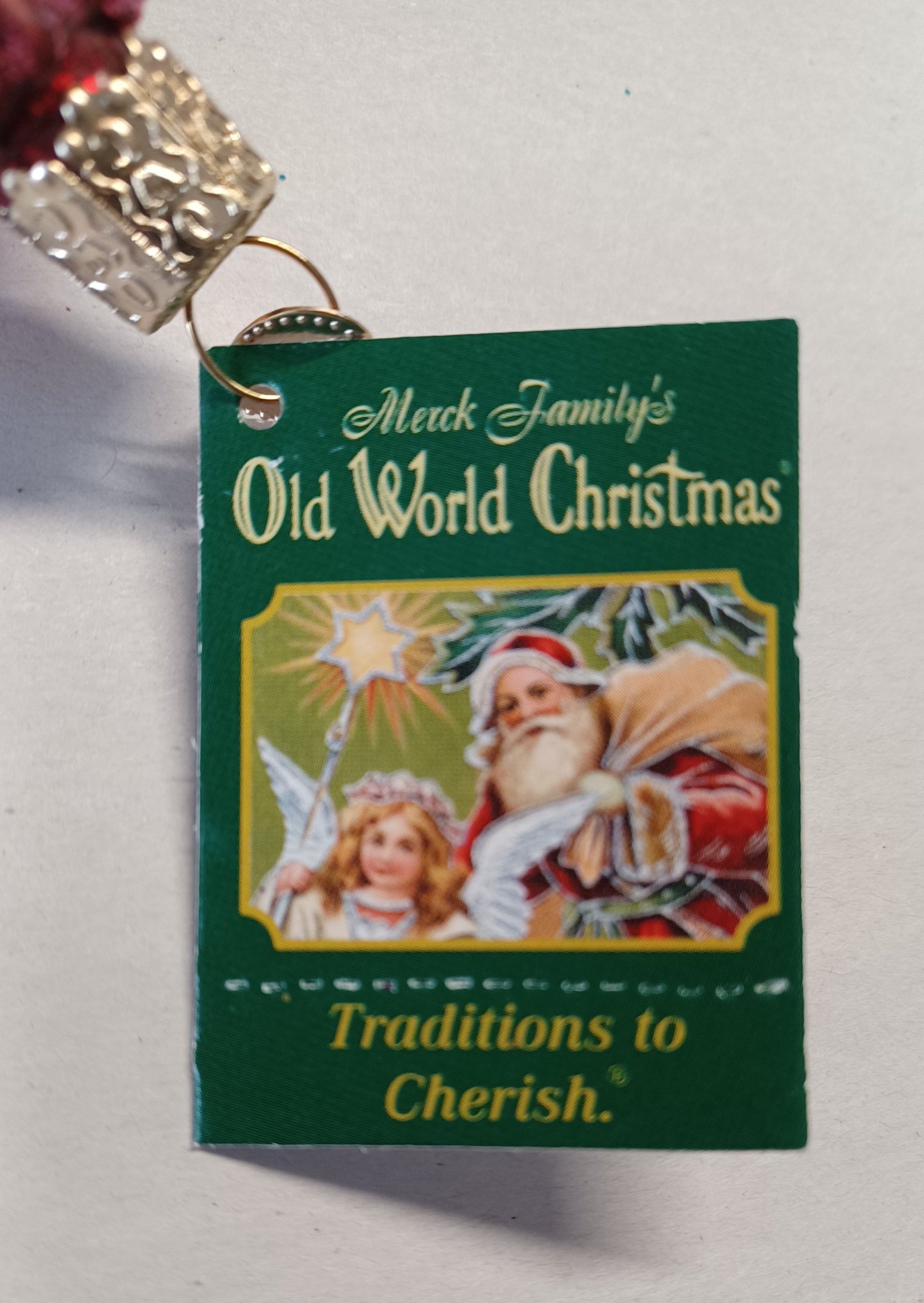Green tag from Old World Christmas on the Dressed Up Teddy Bear blown glass ornament.
