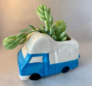 This cute glazed ceramic planter has a blue truck body with white camper shell, white windows and bumpers, and black tires. Its simplified look gives it a child-like whimsy and would look wonderful on a dresser or patio table.