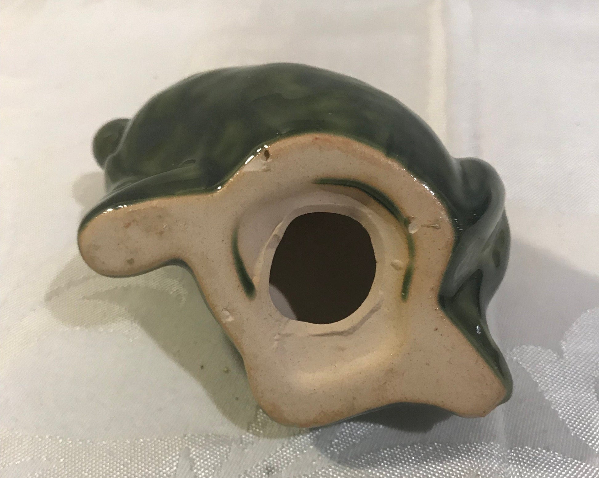 showing the bottom of the ceramic frog knickknack for windowsill or garden.